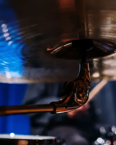Close-up of a crash cymbal under warm stage light